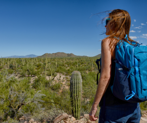 featured image showing a view of a hiker in Tucson with a backpack looking over the desert landscape